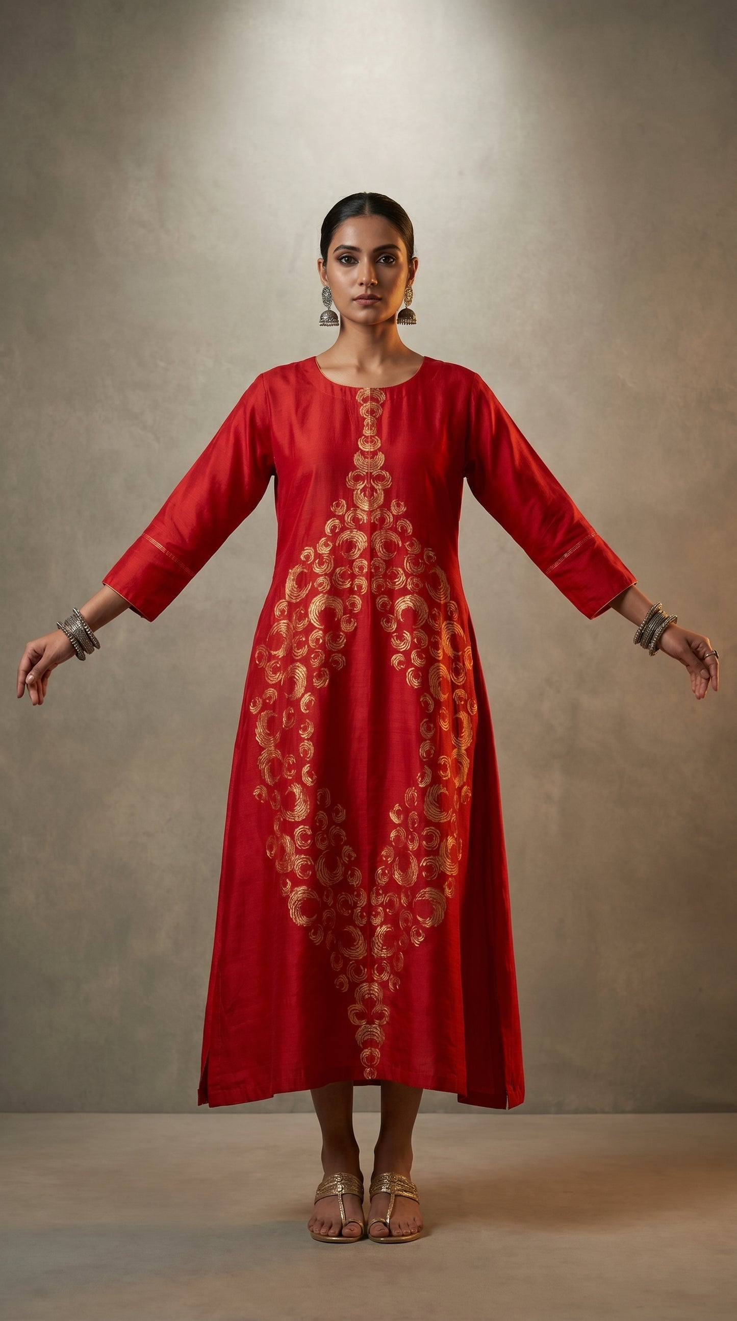 Woman wearing a red embroidered dress against a neutral background