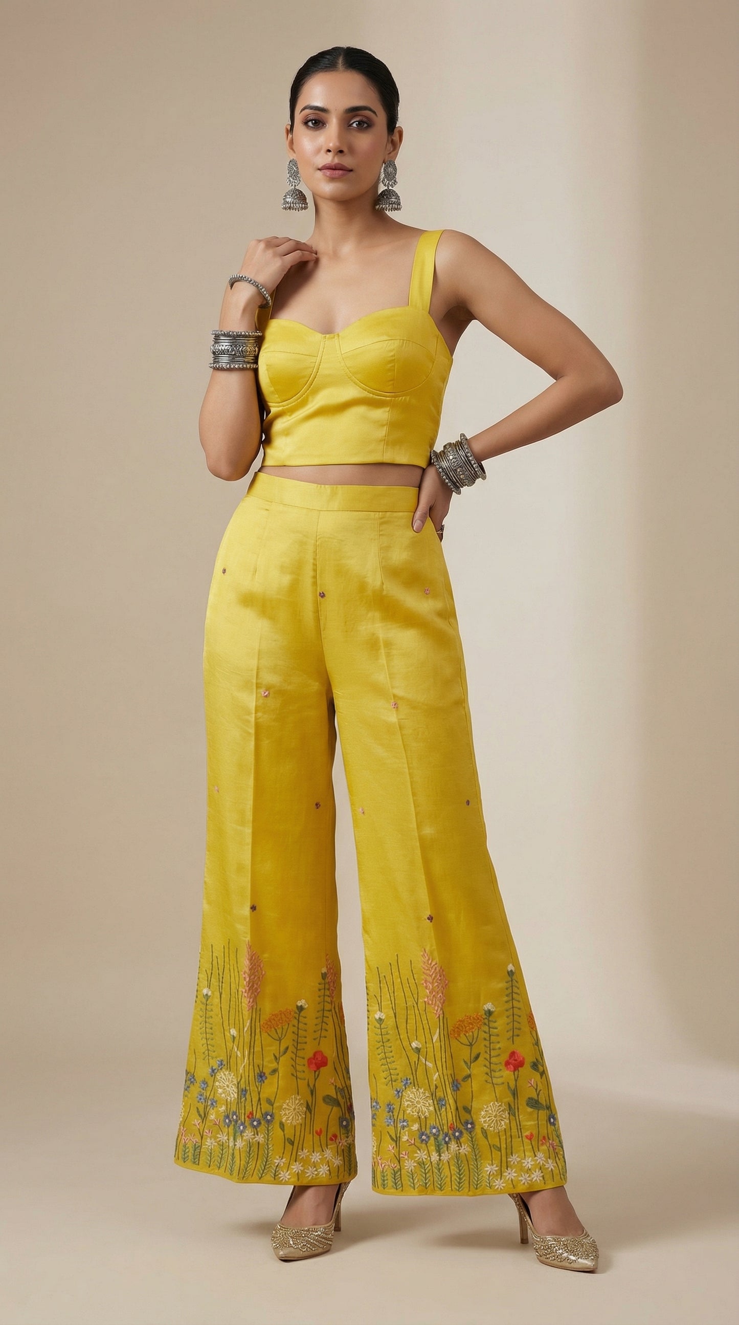 Woman wearing a yellow plazzo with floral embroidery on a beige background