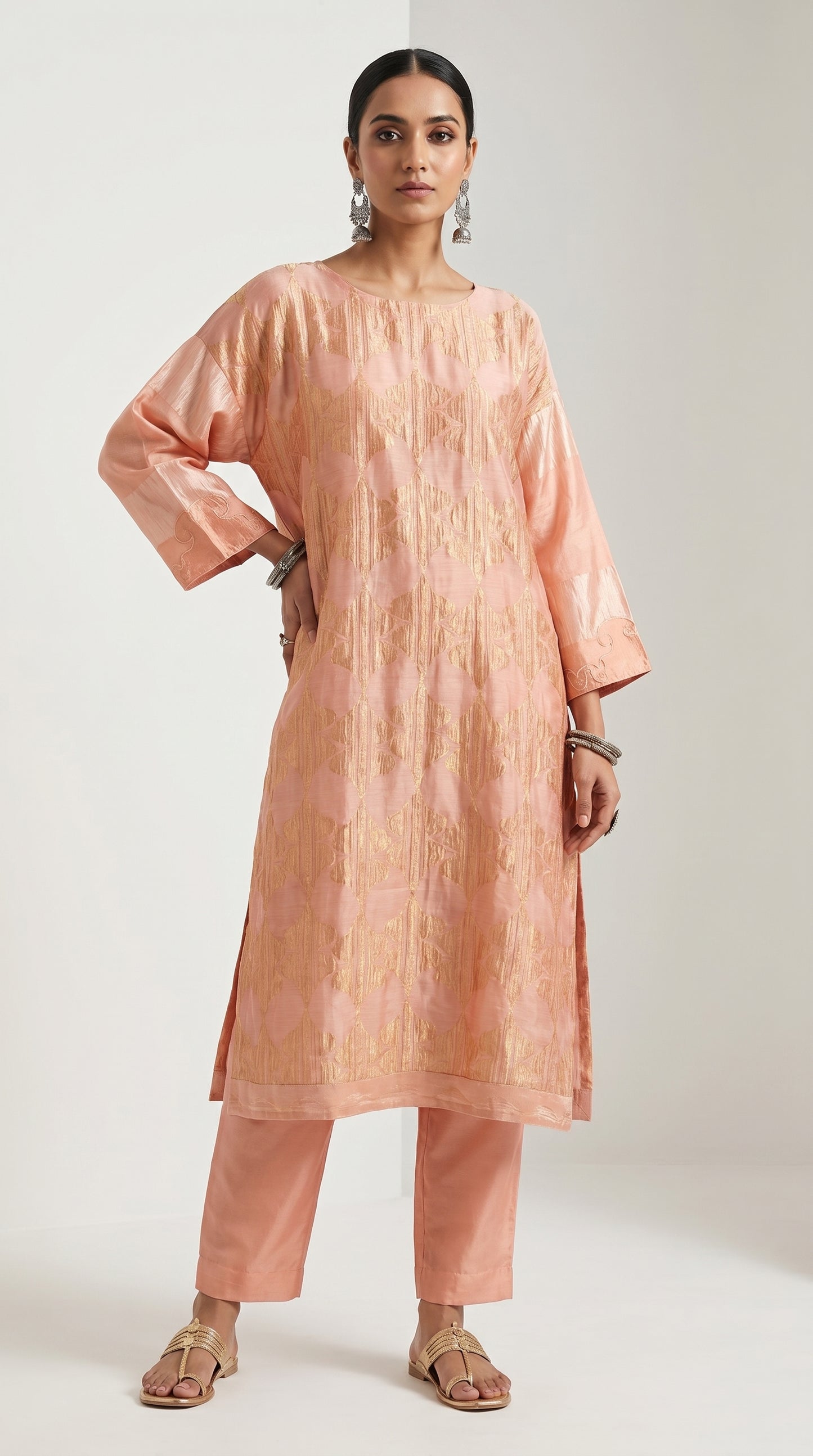 Woman wearing a peach kurta with pants on a white background
