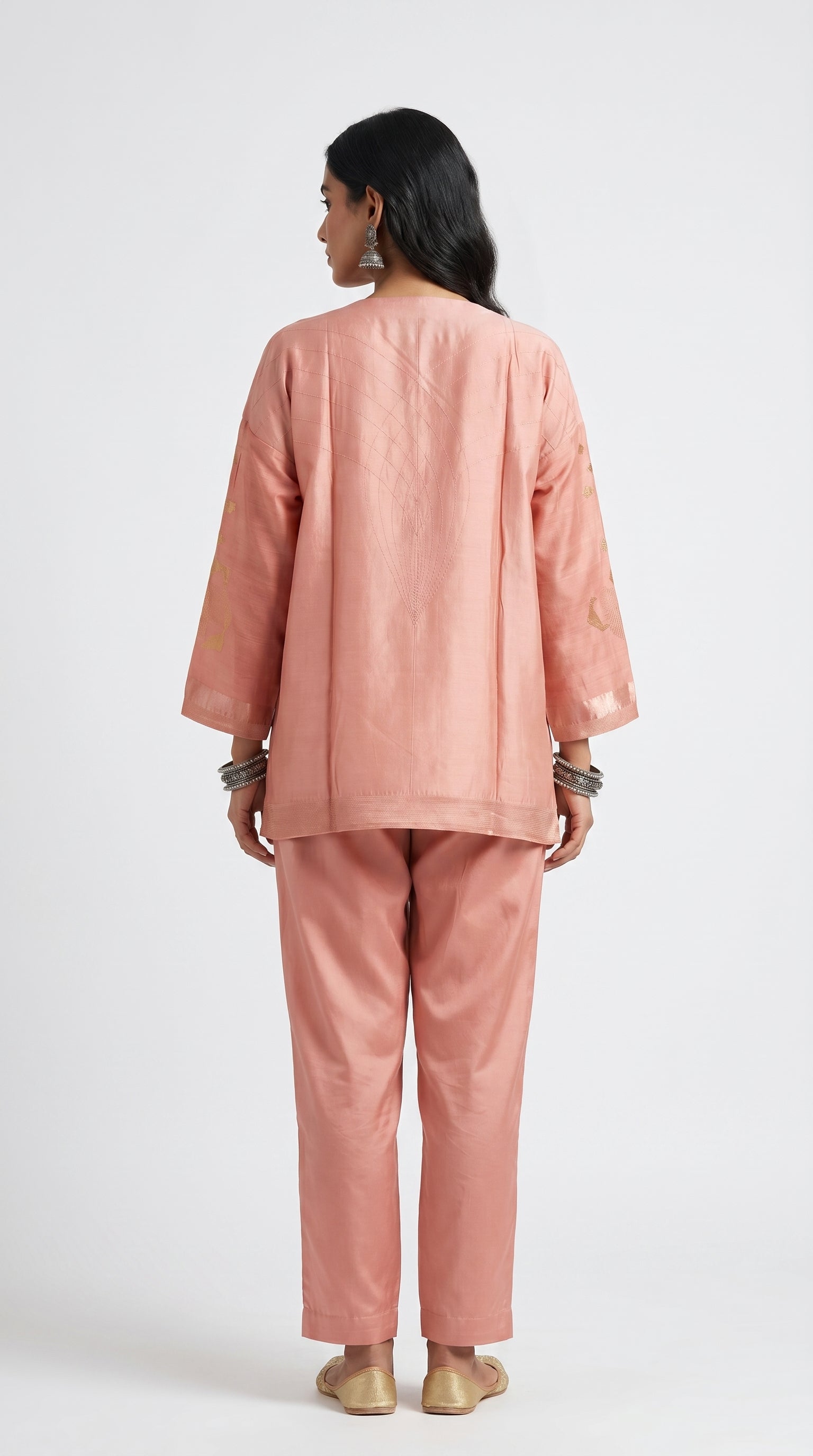 Person wearing a pink outfit on a white background