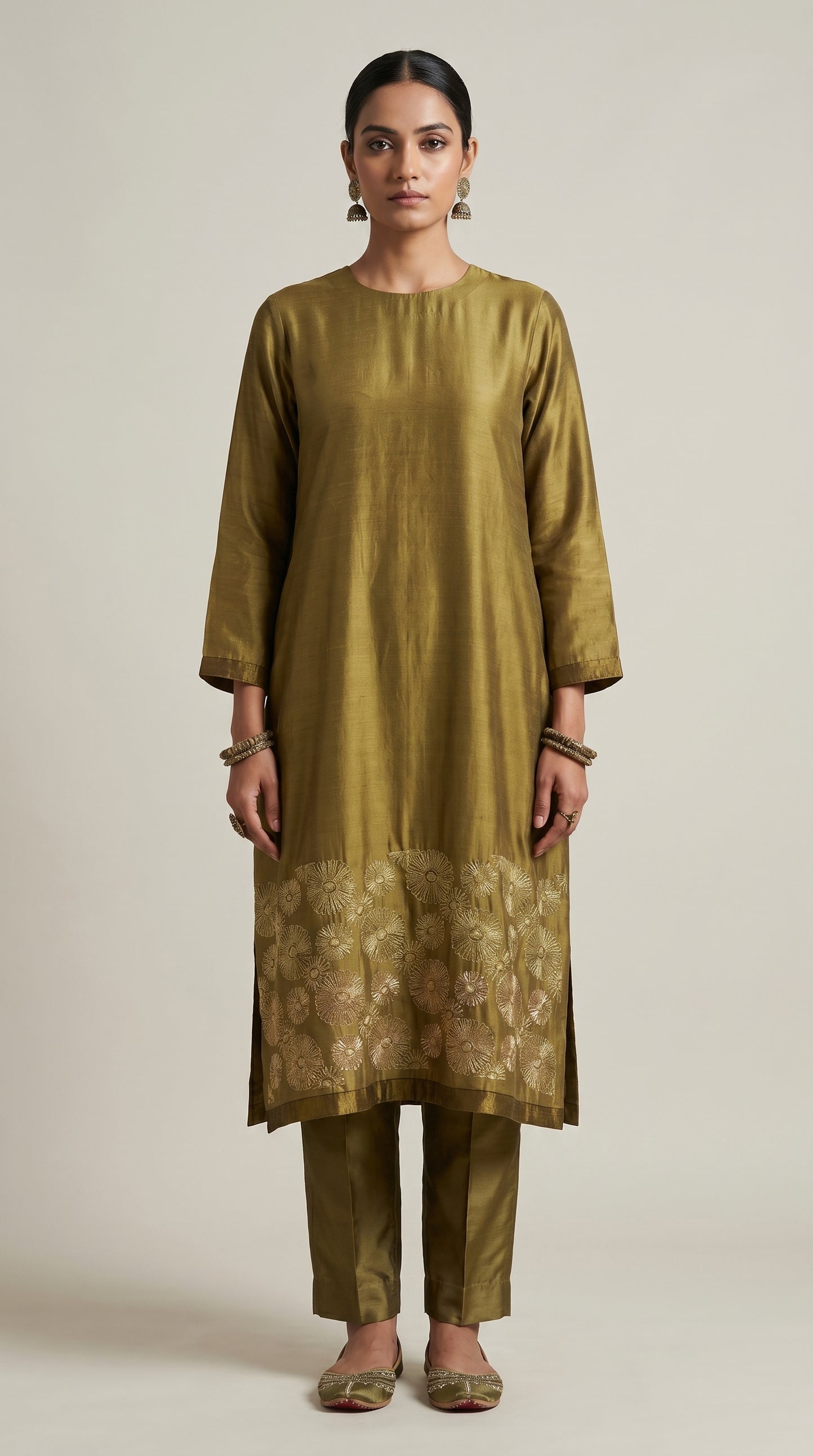 Woman wearing a green traditional kurta with a plain background