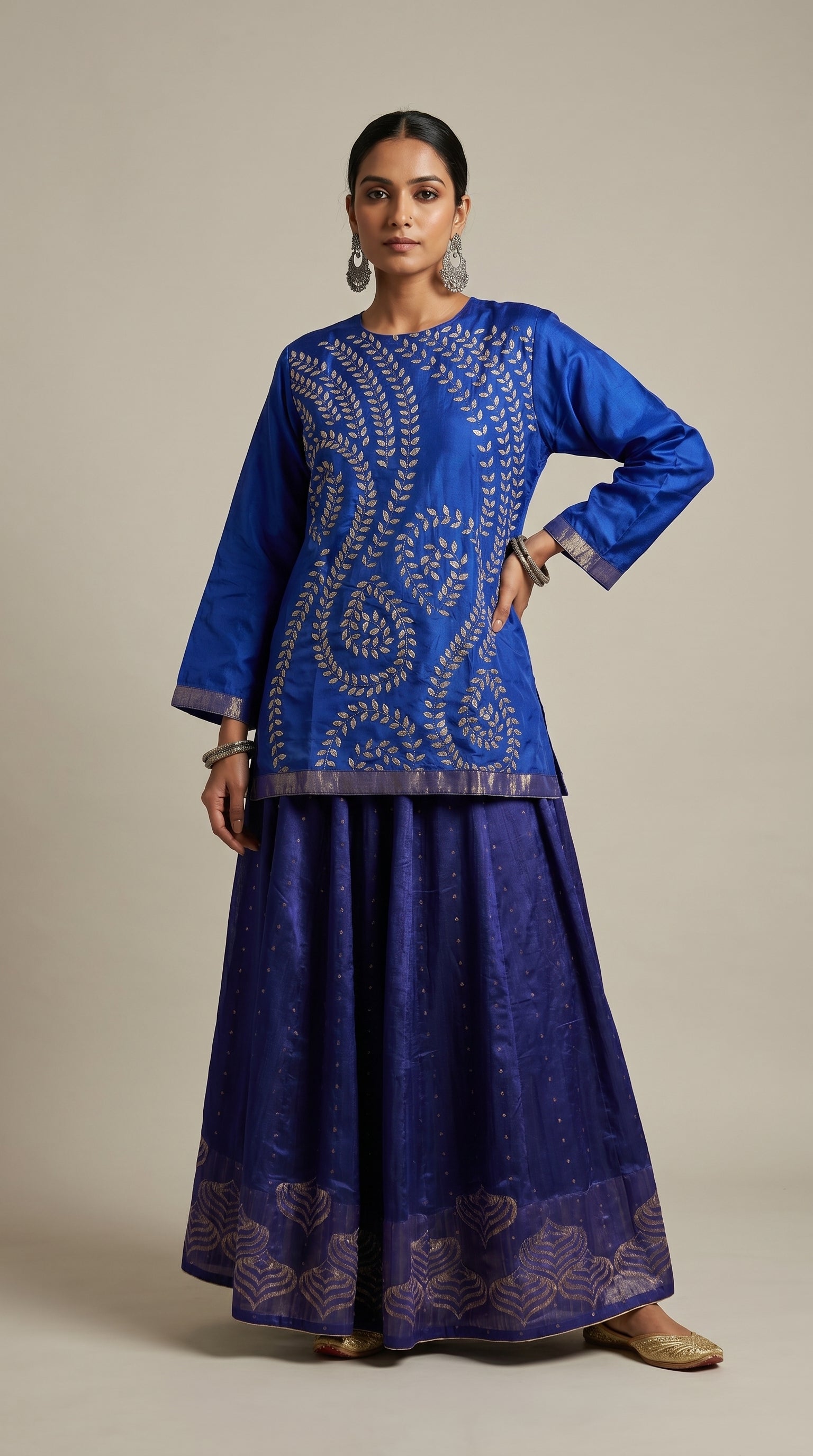 Woman wearing a blue embroidered skirt set on a beige background