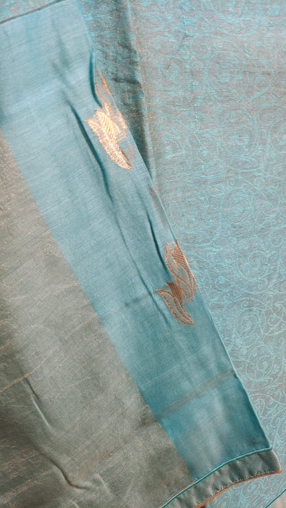 Teal fabric with gold embroidery on a textured background