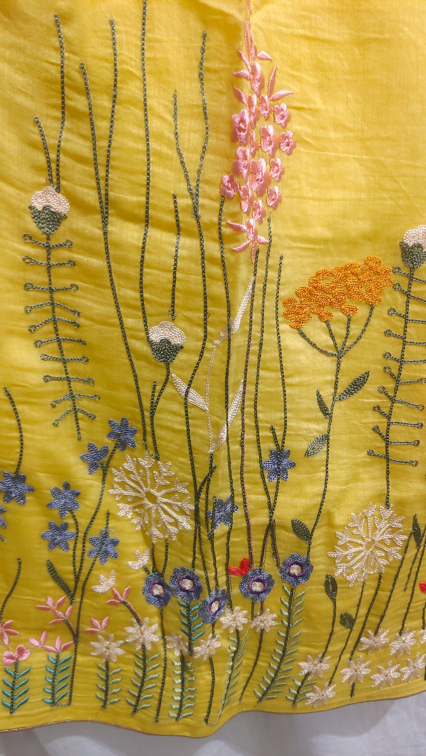 Embroidered floral design on a yellow fabric background