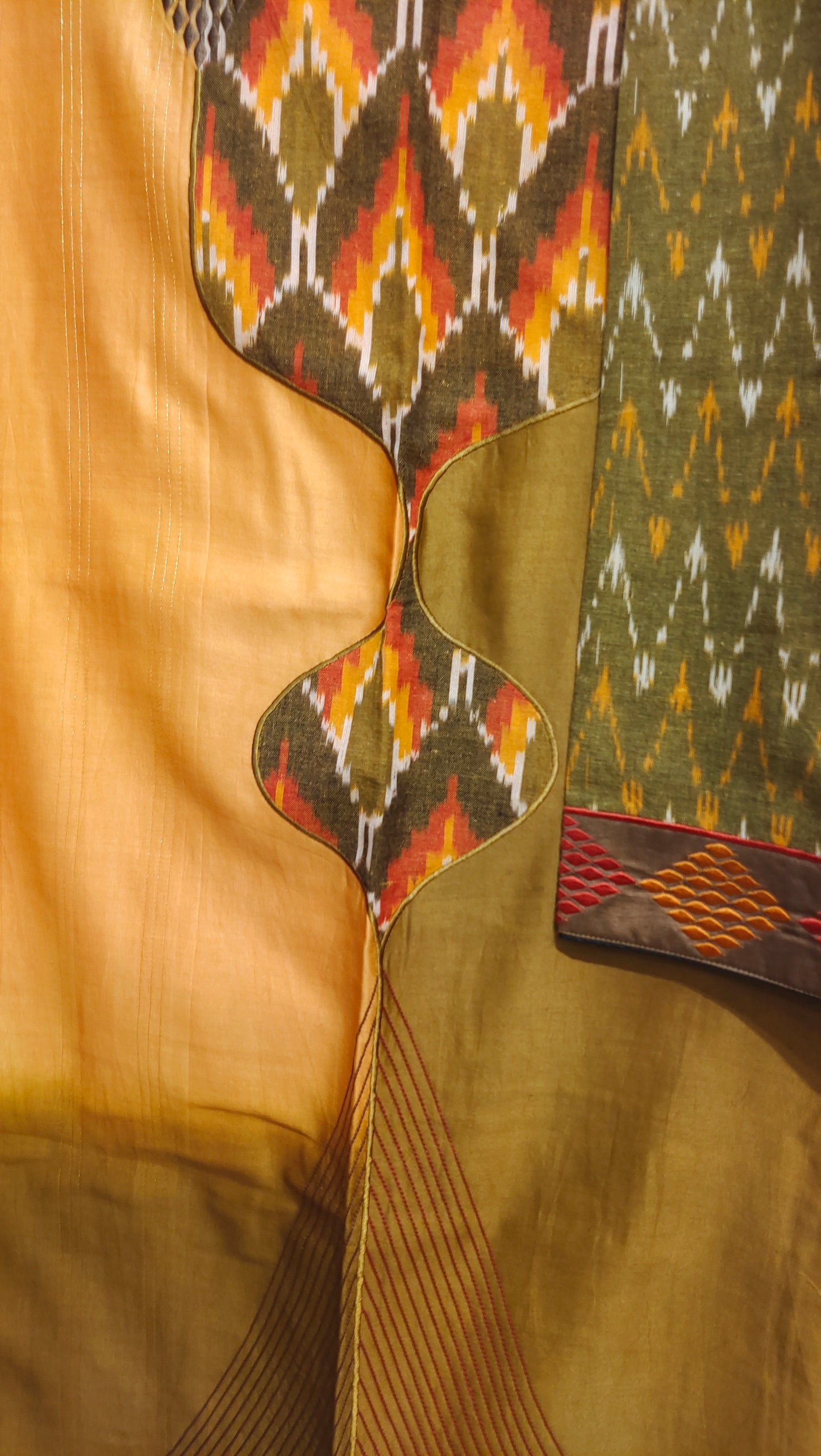 Close-up of a guitar with a patterned headstock against a textured fabric background