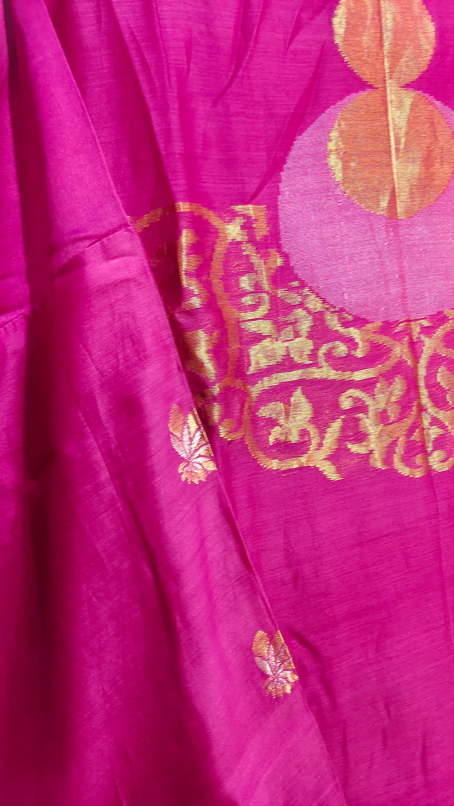 Close-up of pink fabric with gold embroidery