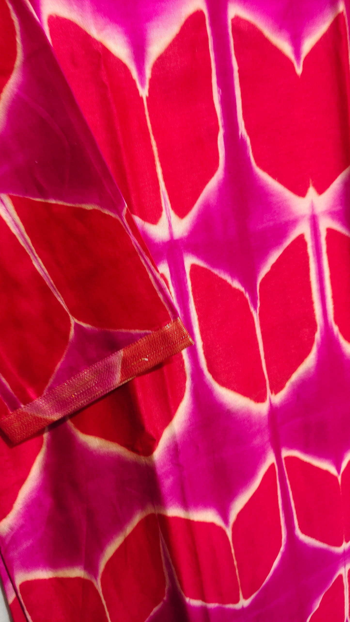 Close-up of a fabric with red and pink tie-dye pattern