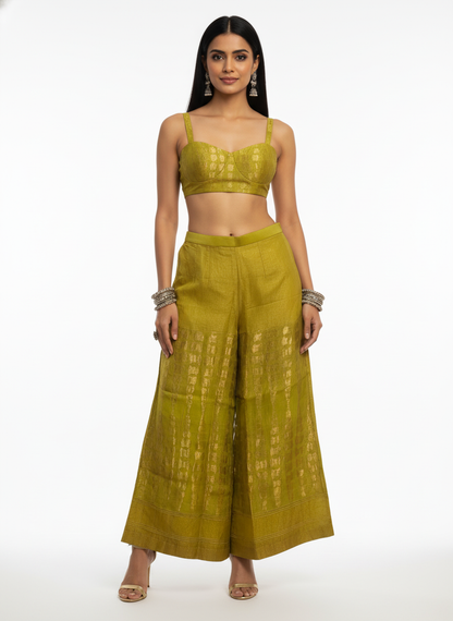 Woman wearing a green traditional plazzo pant with a white background
