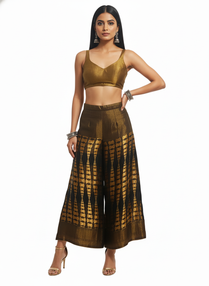 Woman wearing a gold top and black and gold patterned plazzo on a white background