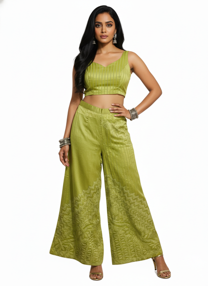 Woman wearing a green plazzo with wide-leg pants and a top on a white background