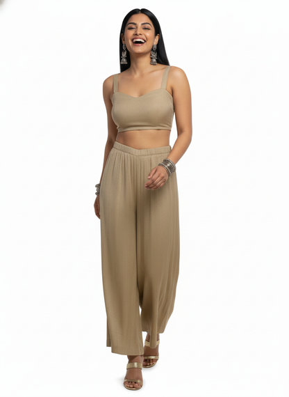 Woman wearing a beige  top and wide-leg plazzo pant a white background