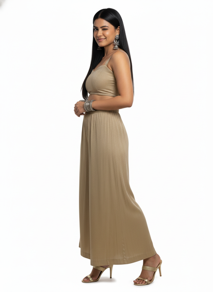Woman wearing a beige plazzo pant a white background