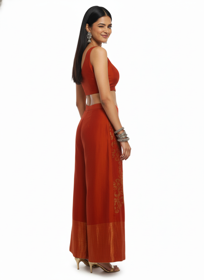 Woman wearing a rust-colored plazzo pant with a white background